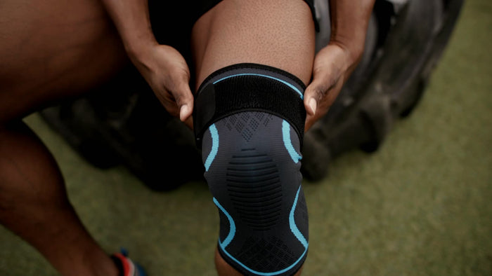 Athlete pulling the knee brace over his knee